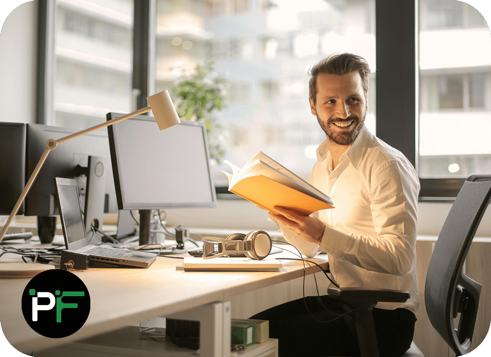 Business man at a computer smiling representing power apps for business workflow